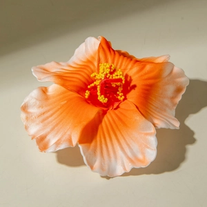 Macro shot of lily hair clip showing realistic orange gradient silk petals and stamen