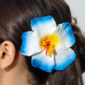 Detail of a large hibiscus hair clip with blue gradient petals on brown hair