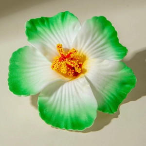 Macro shot of lily flower hair clip with green-to-white petals and red stamens detail