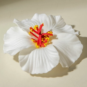 Detailed macro view of a lifelike white lily hair clip with delicate red stamen texture