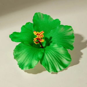 Detail shot of green lily flower hair clip with realistic textures and stamens