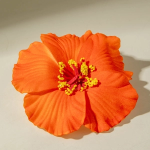 Close-up of vibrant orange lily hair clip with realistic red stamen and fabric texture