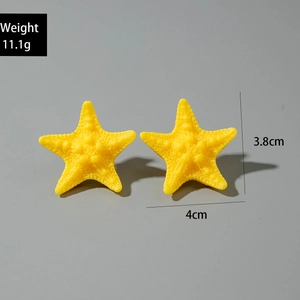 Detail view of yellow starfish earrings showing 4cm size and resin texture