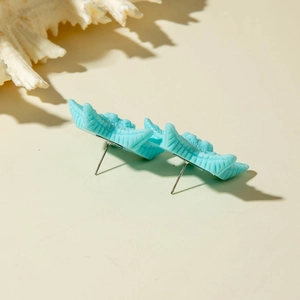 Detail of sky blue starfish resin earrings with silver needle on a beach theme