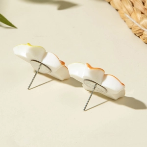 Detail view of resin daisy stud earrings with orange gradient petals and silver pins