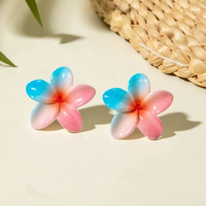 Detailed macro view of summer daisy earrings with blue and orange gradient resin petals