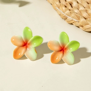 Macro detail of Plumeria flower earrings with tropical green and orange gradient glaze