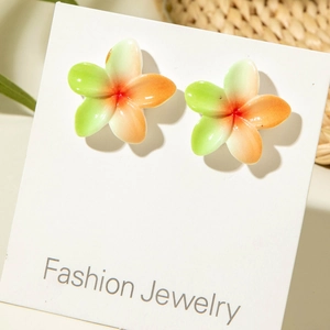Detail of tropical plumeria stud earrings with green and orange gradient resin petals