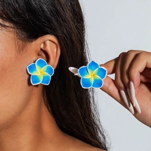 Detailed macro view of plumeria resin earrings with blue and yellow gradient petals