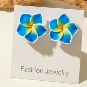 Detailed close-up of blue and yellow gradient resin daisy earrings on a jewelry card