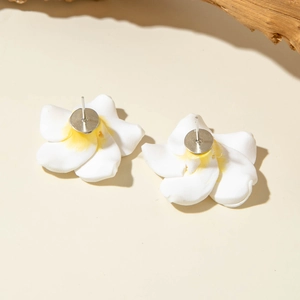 Macro detail of plumeria stud earrings with white and yellow gradient resin petals