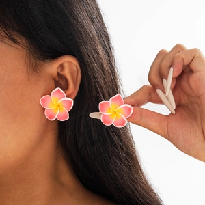 Detail showing the pink and yellow gradient frangipani resin earrings on ear