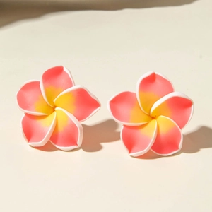 Detail shot of tropical plumeria earrings with pink and yellow gradient resin petals