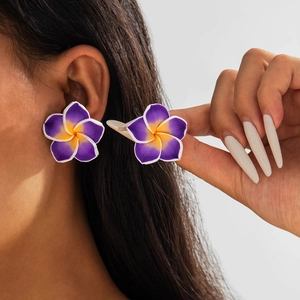 Detail of floral resin earrings with purple and orange gradient petals for summer styling