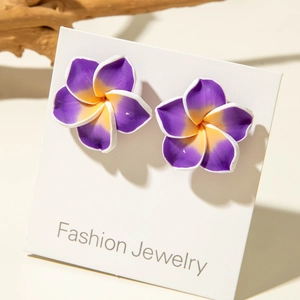 Detail of purple and yellow plumeria resin earrings on a fashion display card