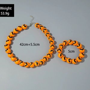 Close-up of Halloween orange beads jewelry set with black bat patterns and silver clasp