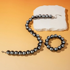 Close-up of Halloween jewelry set with black skull beads on necklace and bracelet