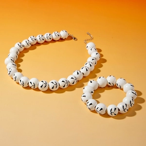 Close-up of Halloween jewelry set with Jack-o'-lantern pattern on white beads