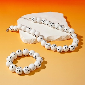 Halloween jewelry set with white pumpkin face beads on stone pedestal background