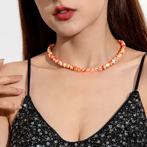 Detailed view of a multi-colored marbled beaded necklace worn by a model in black attire