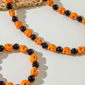 Detailed view of Halloween necklace with orange skull beads and glossy black round beads
