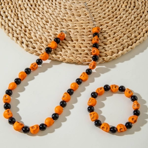 Detail view of Halloween jewelry set with orange skull beads and black round beads