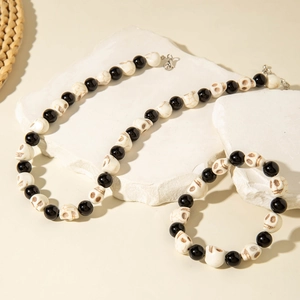 Close-up of Halloween skull bead necklace and bracelet set with black and white accents