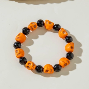 Close-up of Halloween beaded bracelet with orange skull beads and glossy black accents