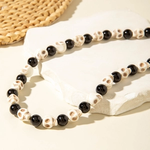 Detailed macro view of gothic necklace with alternating black beads and white skulls