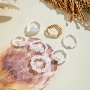 Summer sea style set of 6 pearl and turquoise beaded rings on a decorative seashell