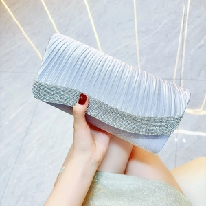 Detail of silver pleated satin evening clutch bag with sparkling rhinestone flap edge