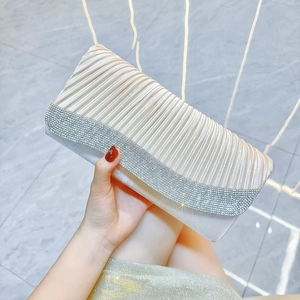 Close-up of pleated fabric dinner clutch featuring elegant rows of silver rhinestones