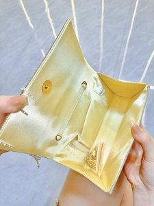 Dettaglio interno della pochette da sera champagne con fodera in raso e catena d'oro