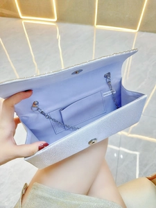 Detail view of the silver glitter evening clutch interior with chain strap and lining