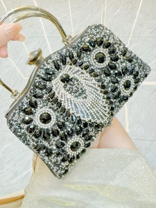 Detail of evening clutch bag with black and white rhinestones and silver handle