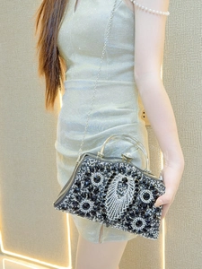Detail of luxury evening clutch bag featuring black and silver rhinestones and gem clasp