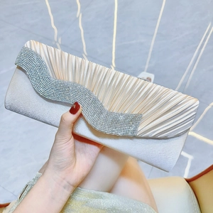 Dettaglio pochette da sera in seta a pieghe con decorazione a onde di strass lucidi