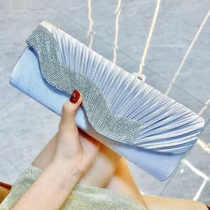 Dettaglio della pochette da sera in raso plissettato azzurro con finiture in strass argentati