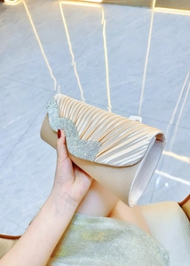 Dettaglio della borsa da sera in seta a pieghe oro champagne con decoro in strass