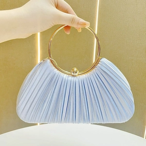 Detail of light blue pleated satin evening bag with a round gold metal ring handle
