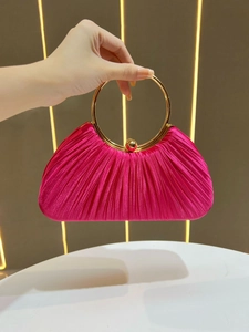 Detail of rose red pleated satin evening bag with a round gold metal ring handle