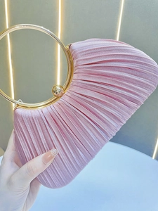 Close-up of pink pleated satin evening bag featuring a gold round metal ring handle