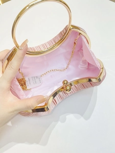 Detailed interior view of pink pleated evening bag with gold handle and chain strap