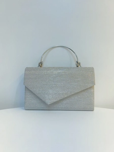 Detail of silver sequin evening clutch with metal handle and triangular flap design