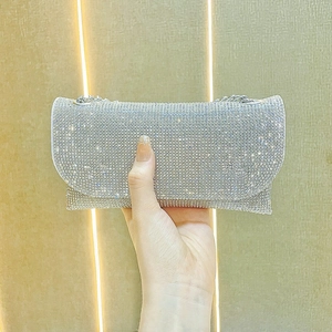 Macro shot of rectangular evening bag with shimmering crystals and silver chain strap