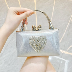 Detail of silver evening clutch with sparkling rhinestone heart and bamboo handle