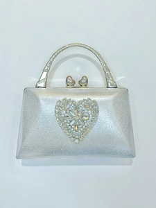 Detailed close-up of a silver clutch with heart-shaped crystal embellishments and metal handle