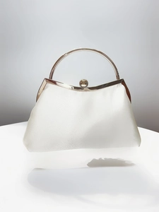 Detail of white satin evening bag with silver ring handle and spherical metal clasp