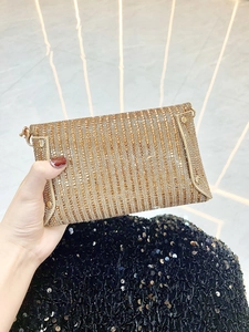 Gros plan sur la pochette de soirée dorée champagne avec strass scintillants et chaîne