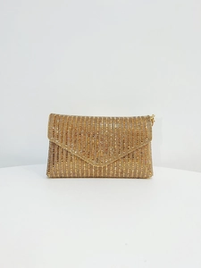 Détail d'une pochette de soirée dorée avec strass verticaux et rabat en forme de V